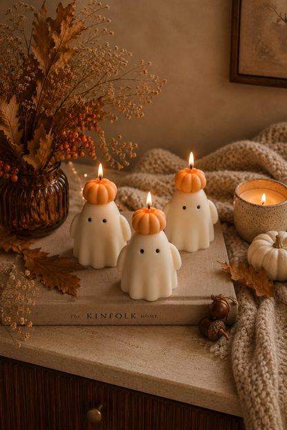 Handmade soy wax ghost candle wearing a small orange pumpkin hat