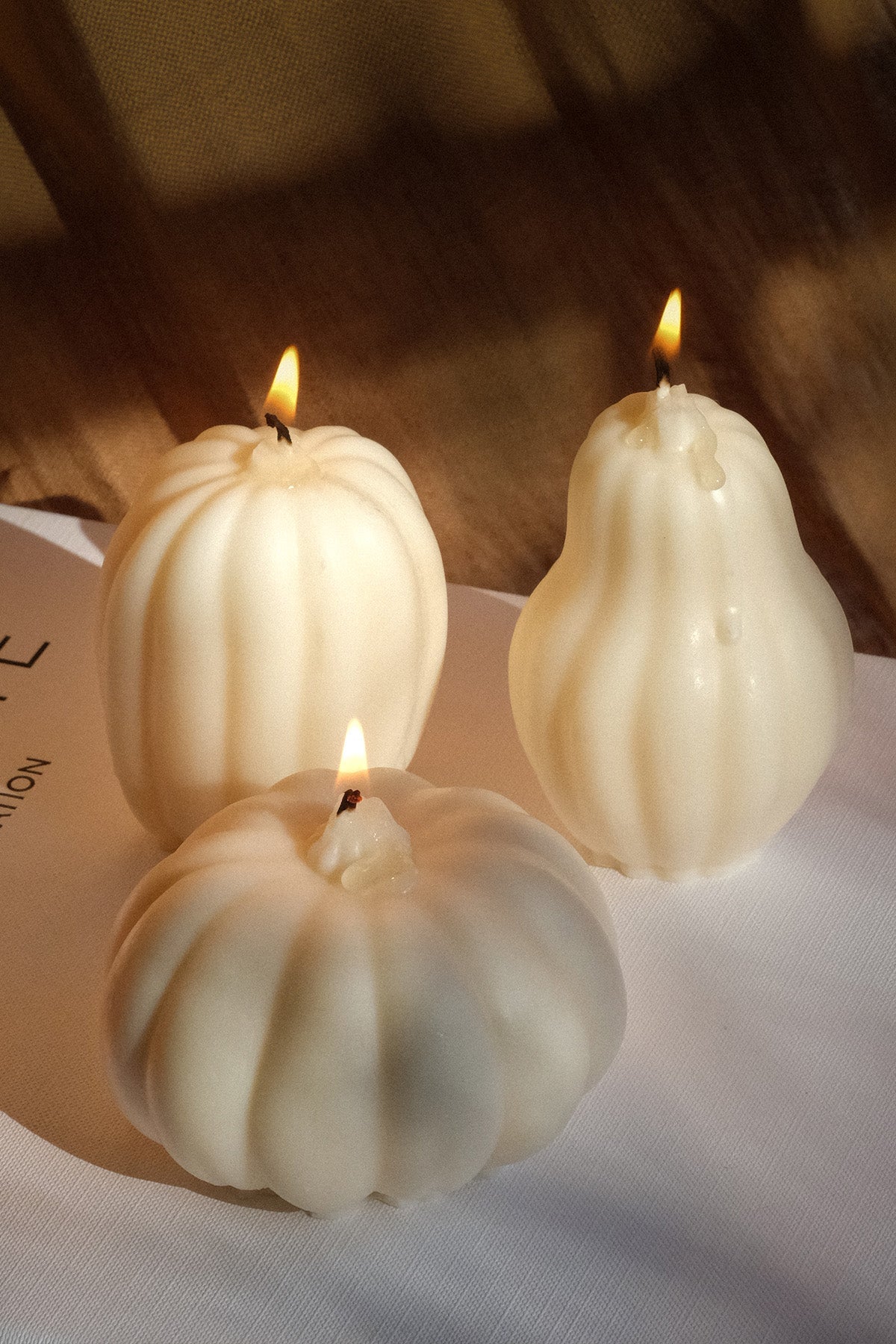 Three handmade soy wax pumpkin shaped candles in different sizes
